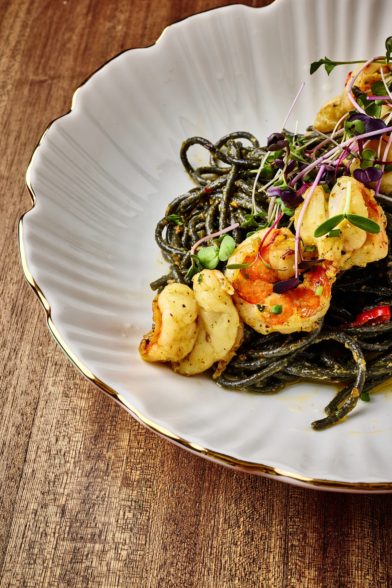 Black pasta topped with prawns and fresh herbs